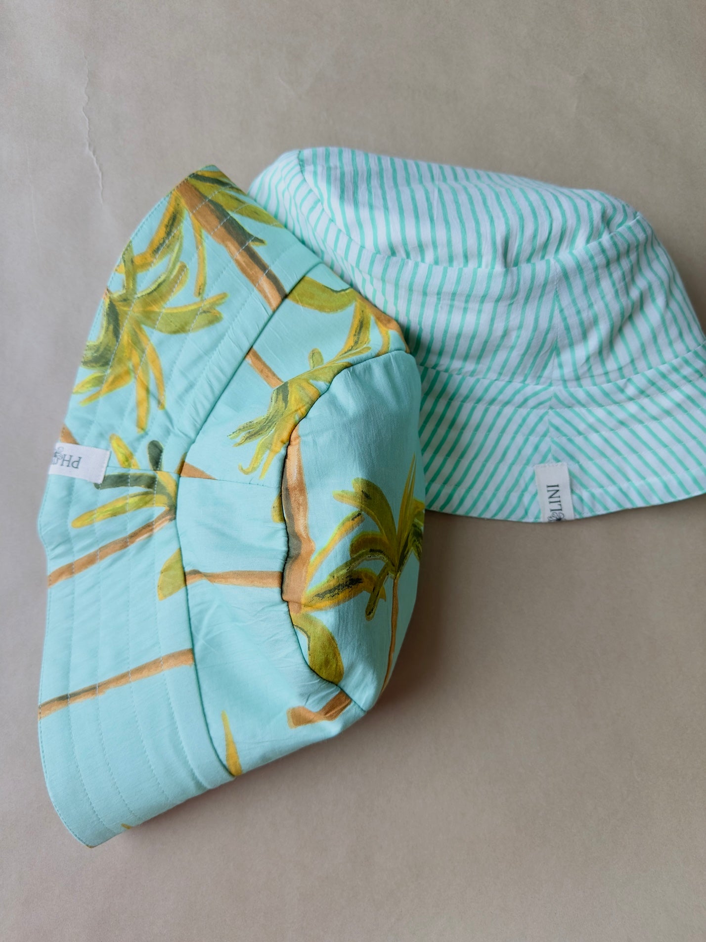 Unisex reversible  hat with palm trees and green sky
Stay cool and stylish with our Cotton Reversible Bucket Hat – two stylish looks in one comfy, breathable, light-weight hat. Crafted from 100% cotton, it’s perfect for sunny days, travel, or casual outings.

2 in 1 style - Flip it to match your mood or outfit!