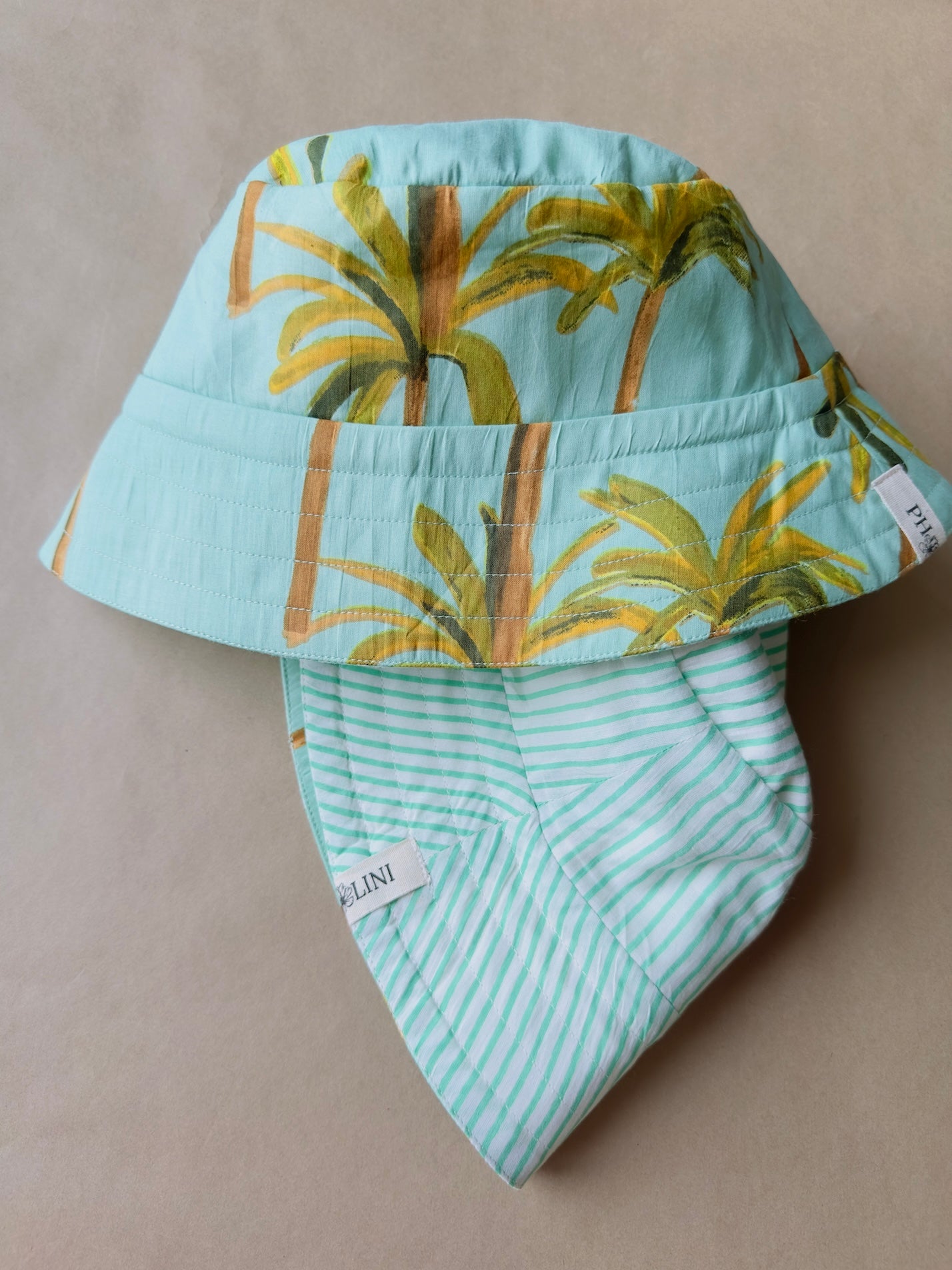 Unisex reversible  hat with palm trees and green sky
Stay cool and stylish with our Cotton Reversible Bucket Hat – two stylish looks in one comfy, breathable, light-weight hat. Crafted from 100% cotton, it’s perfect for sunny days, travel, or casual outings.

2 in 1 style - Flip it to match your mood or outfit!
