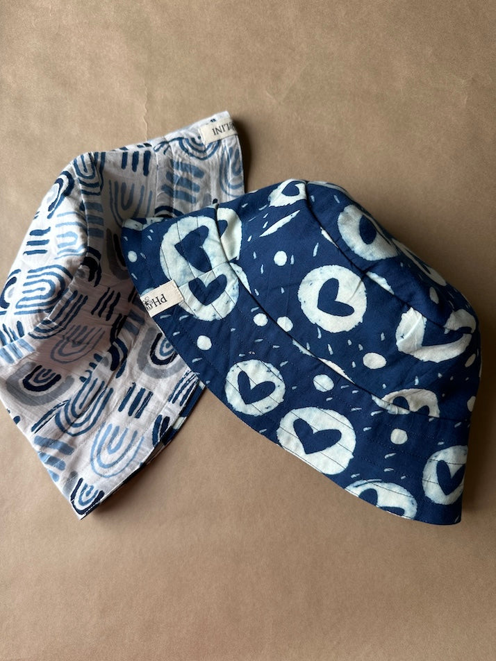Unisex reversible  hat with blue heart print and aesthetics
Stay cool and stylish with our Cotton Reversible Bucket Hat – two stylish looks in one comfy, breathable, light-weight hat. Crafted from 100% cotton, it’s perfect for sunny days, travel, or casual outings.

2 in 1 style - Flip it to match your mood or outfit!
